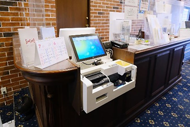 切断したカウンターにレジと自動釣銭機を設置