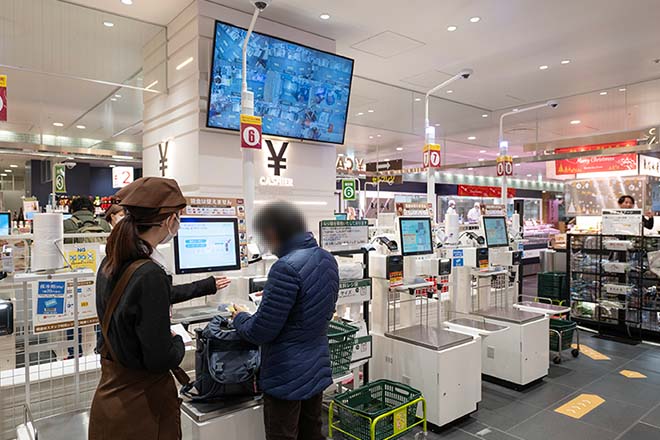 セルフレジでお客様にご説明する従業員のイメージ画像