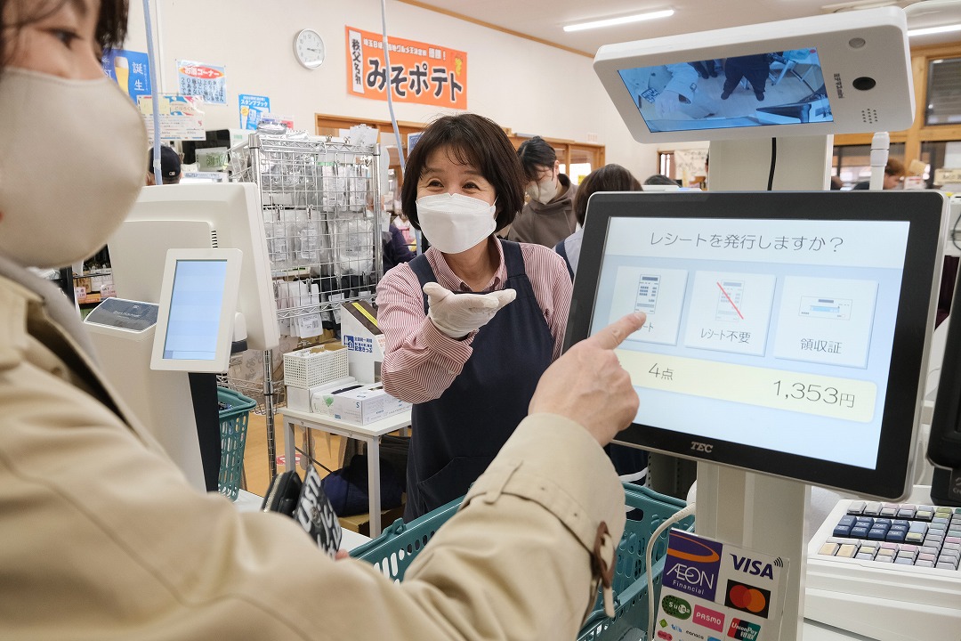 お客様自身が自動釣銭機で支払いっている画像