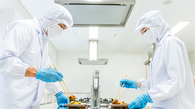 お弁当におかずを詰める職員のイメージ画像