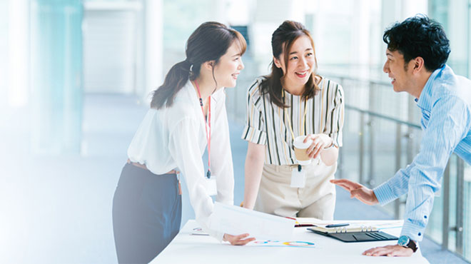 笑顔で話し合う二人の女性と男性のイメージ画像