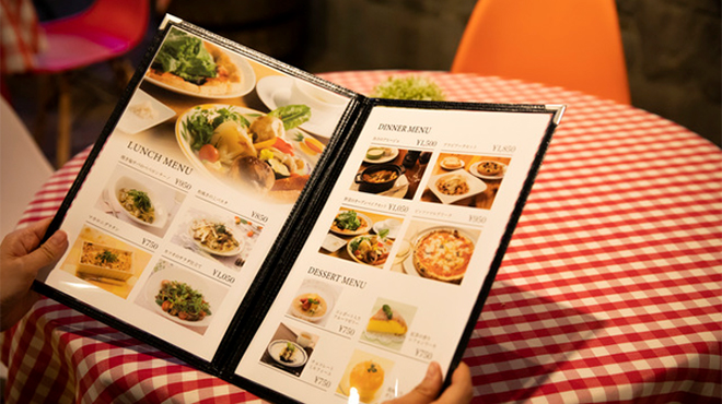 飲食店でメニューを広げているイメージ画像