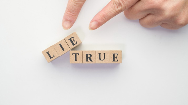 「LIE」と「TRUE」と書かれた積み木と「LIE」を示す指のイメージ画像