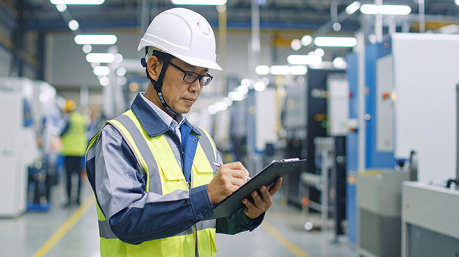 男性が工場内で確認作業をしているイメージ画像
