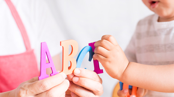 アルファベットのおもちゃを持つ大人と子供のイメージ画像