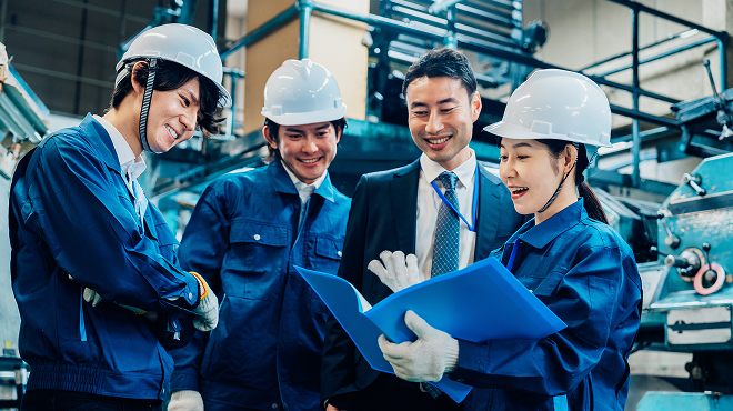 製造業における技術継承と人材育成の現場で管理職と若手作業員が連携する様子