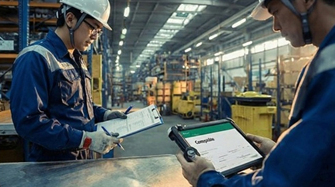 製造、物流の現場で紙の書類とタブレットの両方を使って作業する従業員