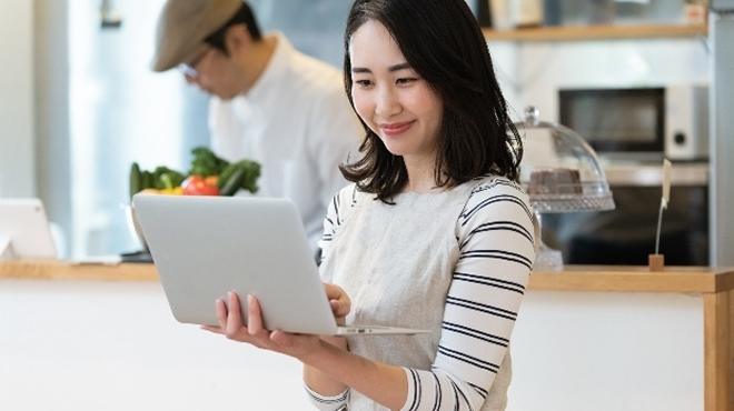 PC画面を確認している店員のイメージ画像