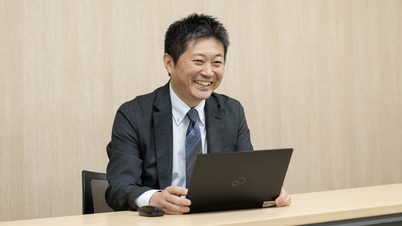 ノートPCを開いて笑顔で会話している画像