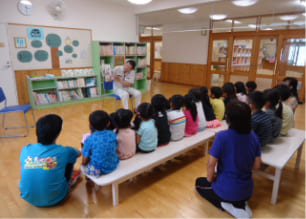 読み聞かせボランティアに聞き入る子供たちの様子