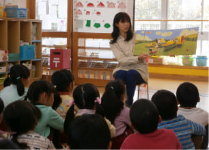 読み聞かせボランティアを行う女性の写真