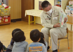 読み聞かせボランティアを行う男性の写真