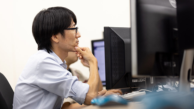 PCをのぞき込みながら考える佐々木氏。