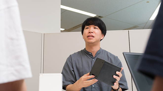製品を手に持ち説明する河田氏。