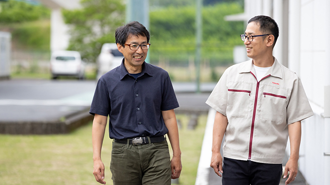 談笑しながら歩く野寺氏と箕浦氏。静岡事業所（大仁）の敷地内にて。
