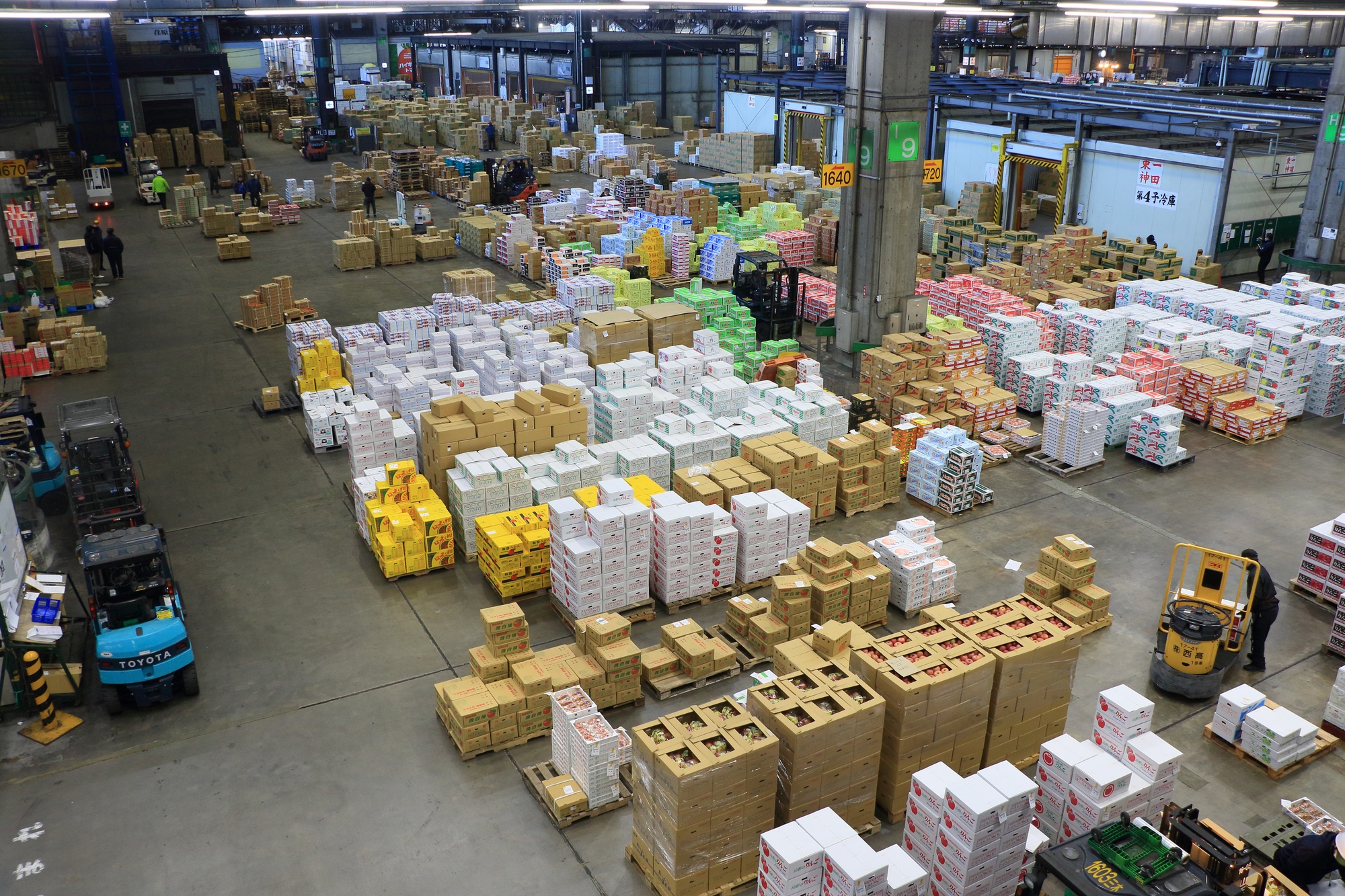 大きな倉庫に荷物が山積みされている写真