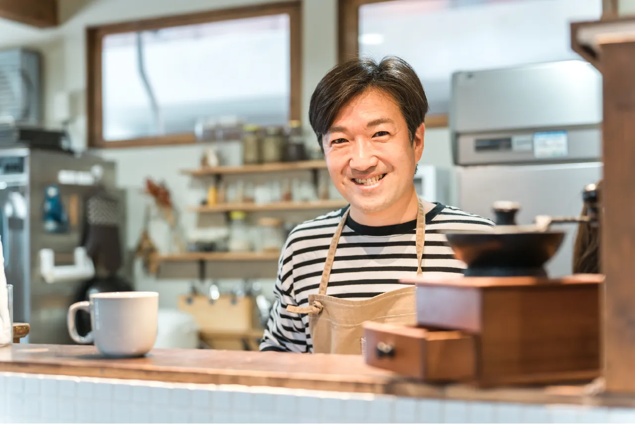 カフェで働く笑顔の男性スタッフ