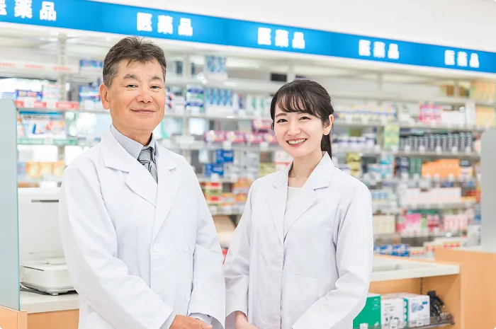 ドラッグストアで働く白衣姿のスタッフ2人