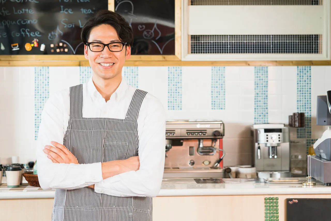 カフェで接客する男性バリスタ