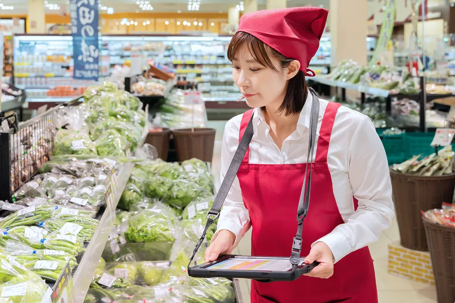 スーパーの青果売り場で働く女性スタッフ