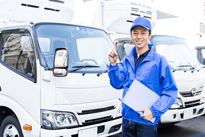 トラックとトラックの前に立っている男性の画像