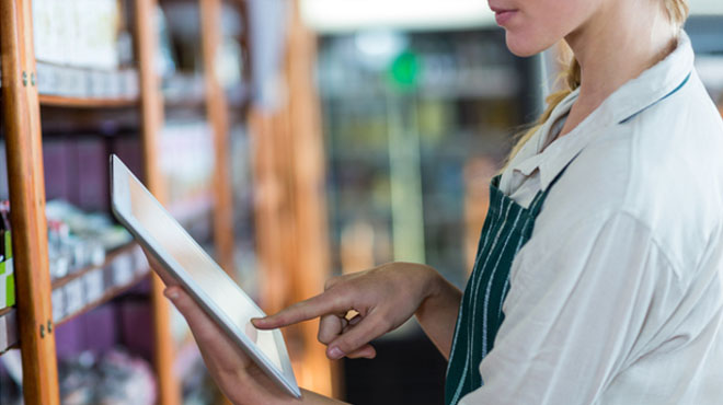 女性店員がタブレット端末を見ているイメージ画像