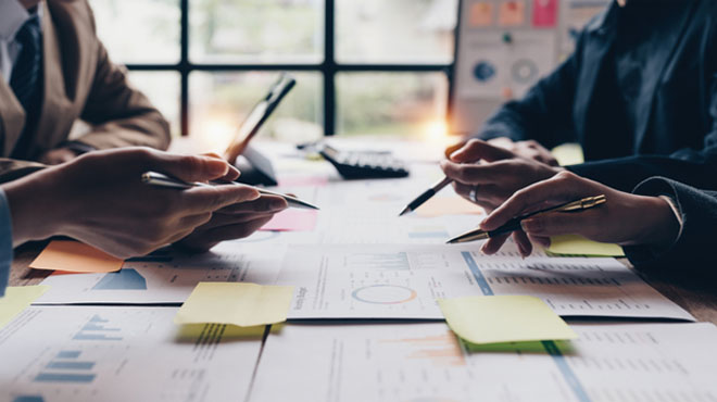 資料を見ながら分析をしているミーティングのイメージ画像