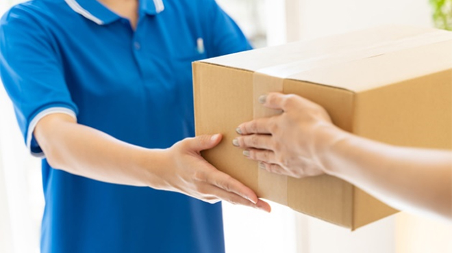 配送業者が段ボールを手渡すイメージ画像