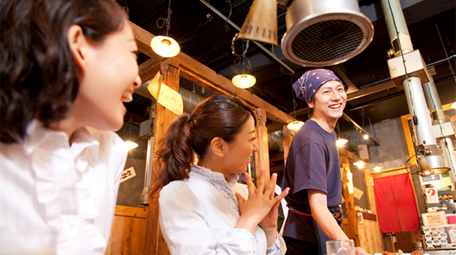 飲食店内で笑顔の客と店員のイメージ画像