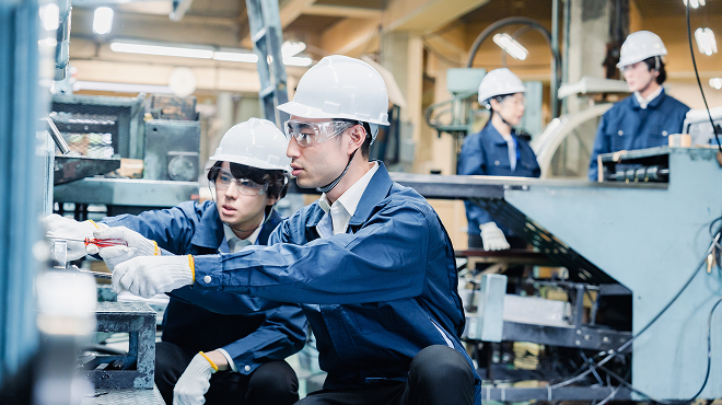 製造業の技能継承問題に対応する熟練技術者による若手への実地指導風景