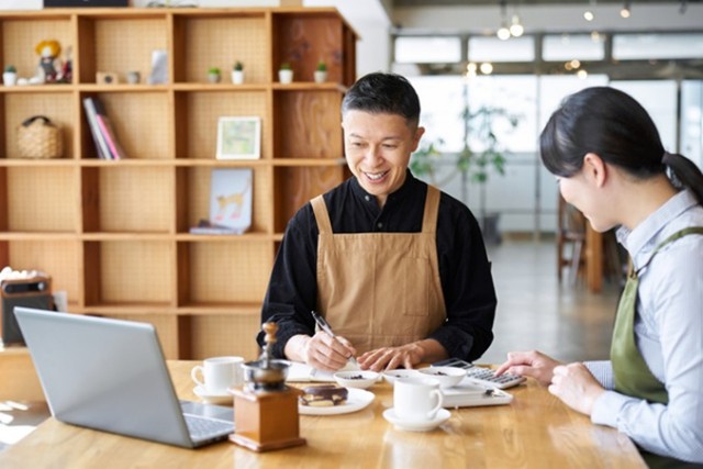 カフェで経営や会計について話し合っている様子のイメージ画像