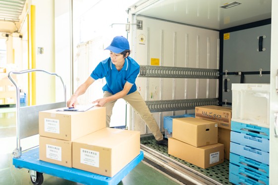 物流拠点で荷物の積み下ろし作業を行う様子のイメージ画像