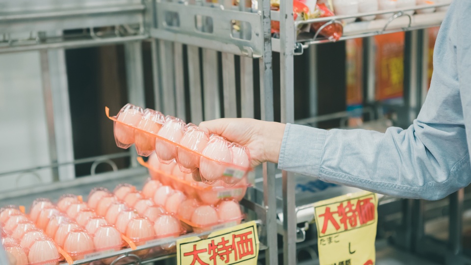 スーパーでお客さんが商品を手に取っているイメージ画像