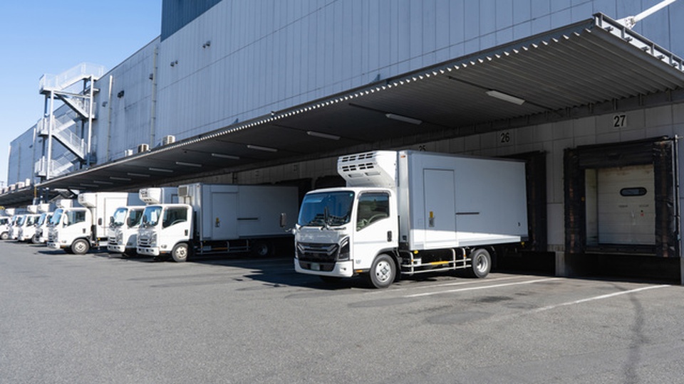 トラックが倉庫前に止まっている画像