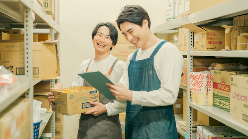 男性スタッフ二人が倉庫で談笑している画像