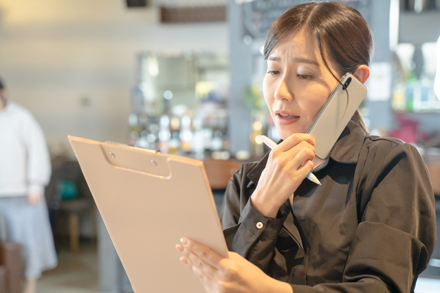 スマホで連絡を取る店員のイメージ画像