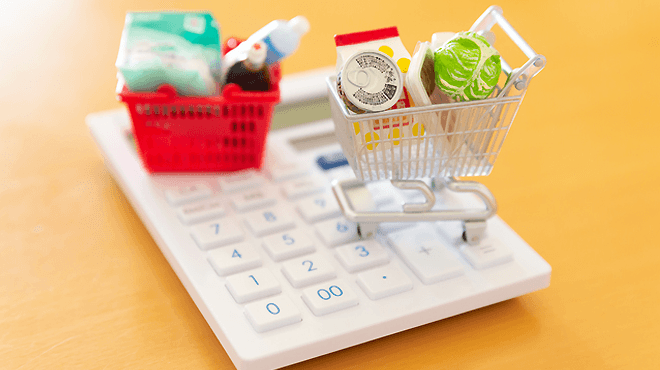 電卓の上に買い物かごが乗っているイメージ写真