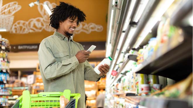 男性がスーパーマーケットにて商品をスマホでスキャンしているイメージ画像