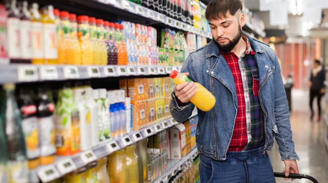 男性がスーパーマーケットにて商品を手にしているイメージ画像