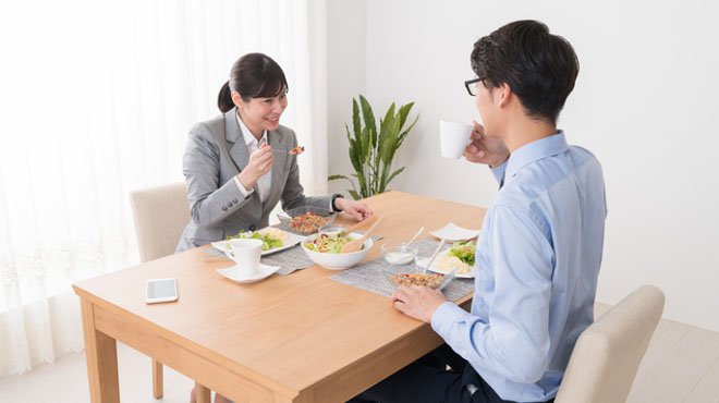 男女が会話しながら食事をしているイメージ画像