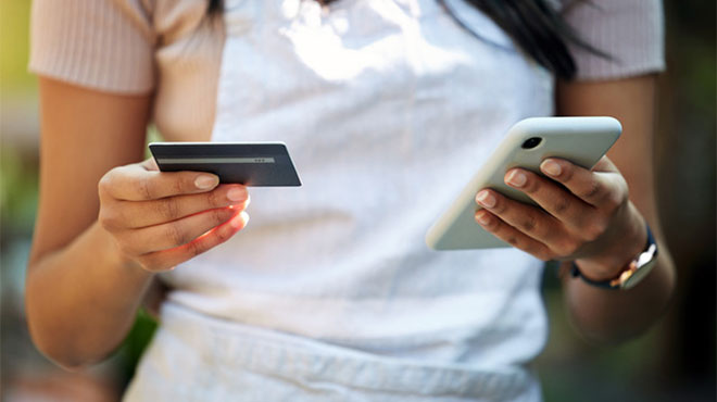 クレジットカードとスマートフォンを持つ人のイメージ画像